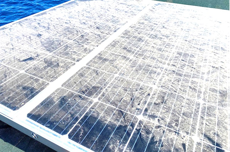 Solar panel with heavy salt and mineral scale buildup near the coast